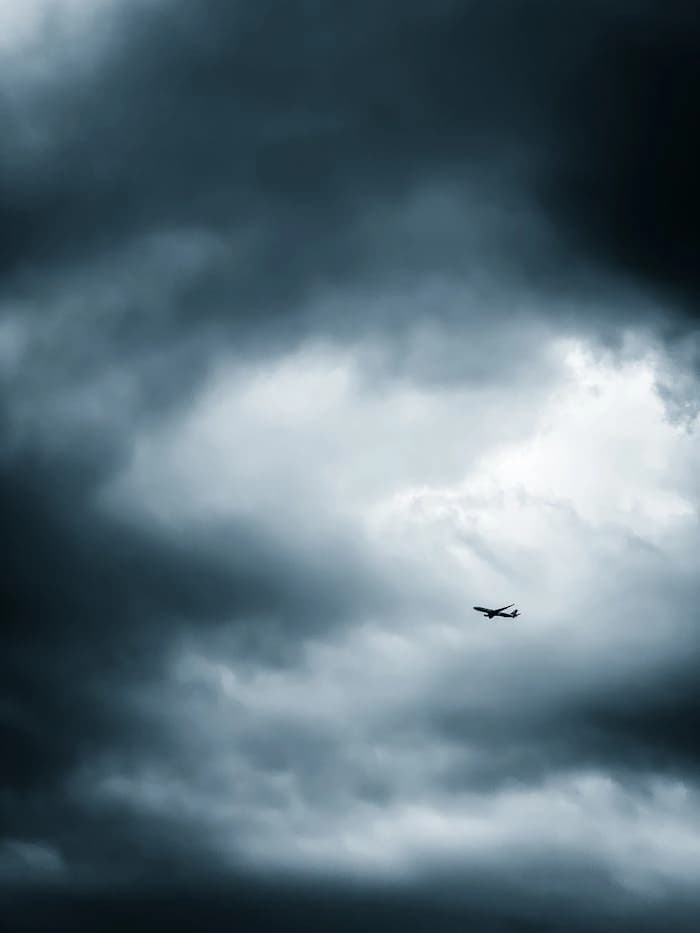 Plane viewed from below against a dramatic sky